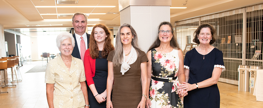 Five women and one man posing for a group photo